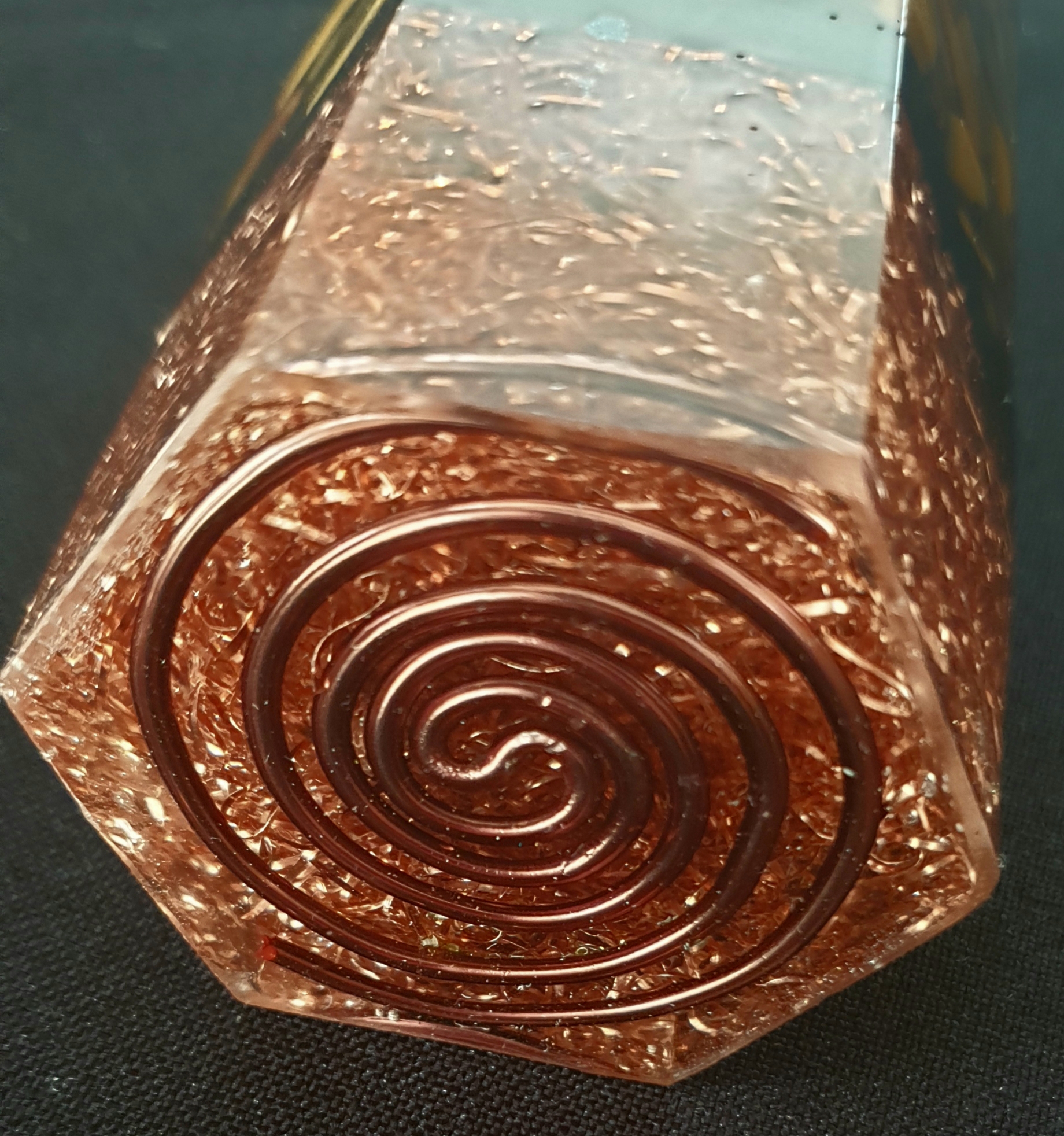 Detailed view of hand-wound copper spiral in resin